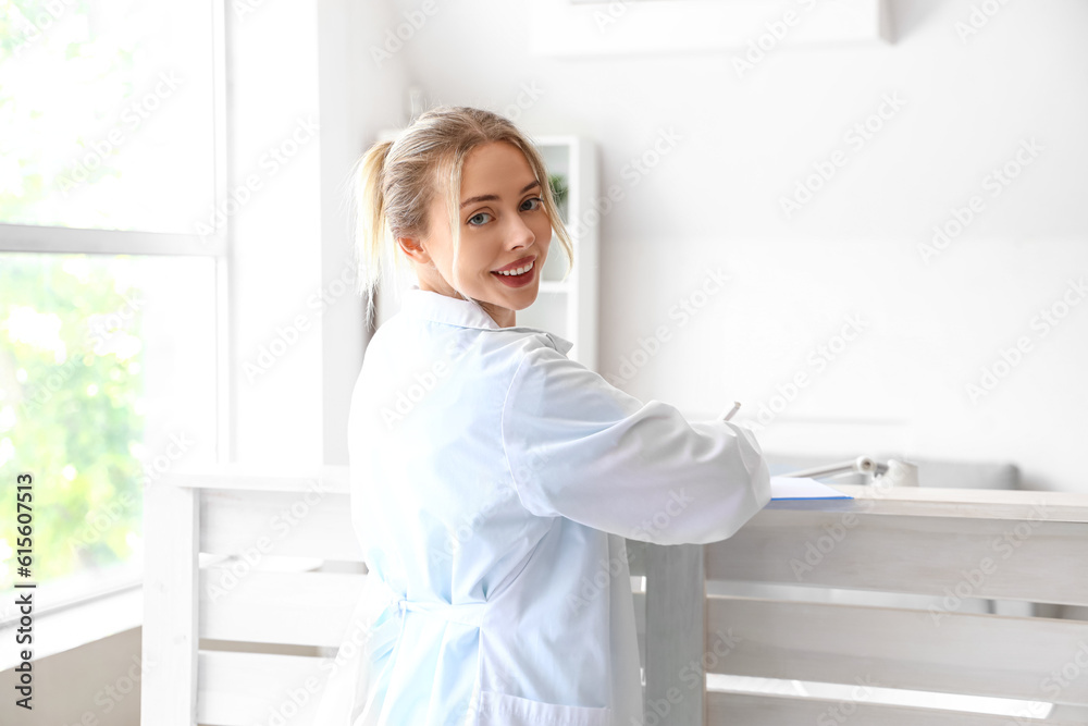 Female doctor writing in clipboard at reception Female doctor writing in clipboard at reception
