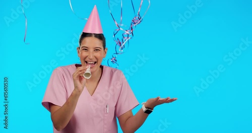 Birthday, party horn and balloons with a woman nurse in studio isolated on a blue background for celebration. Portrait, healthcare and a happy female medicine professional blowing on a noisemaker photo