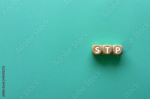 There is wood cube with the word STP. It is an abbreviation for Segmentation, Targeting, Positioning as eye-catching image.