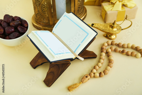 Rehal with Koran, tasbih and dried dates on color background. Islamic New Year celebration photo