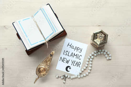 Card with text HAPPY ISLAMIC NEW YEAR, tasbih, Koran and fanous on white wooden background photo