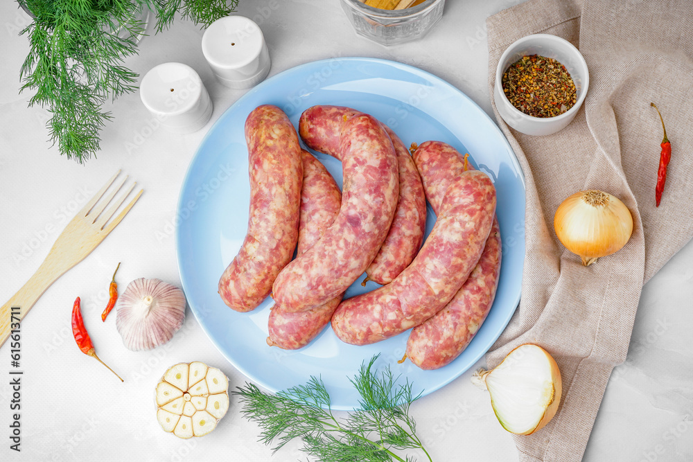 Plate with raw homemade sausages on light background Stock Photo
