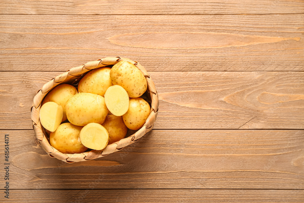 Wicker basket with raw baby potatoes on wooden background Wicker basket with raw baby potatoes on wooden background