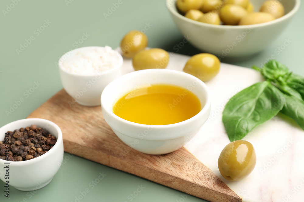 Bowl with fresh olive oil on green background Bowl with fresh olive oil on green background