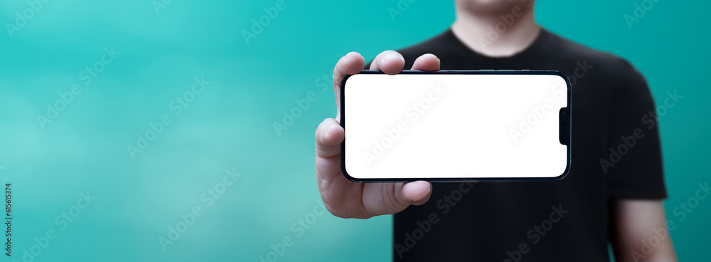 Fototapeta premium cell phone in hand with white screen held horizontally with blue background - easy modification