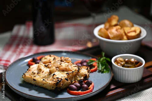 typical portuguese dish roasted codfish with onion garlic peppers and rustic babata lusitanian food