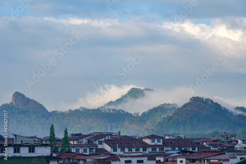 Asian town house and remote mountain in fog in south China © nd700
