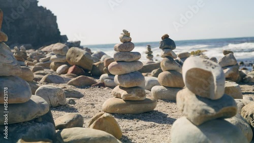 Close up of multiple cairns at beach infront of ocean at cape point national park