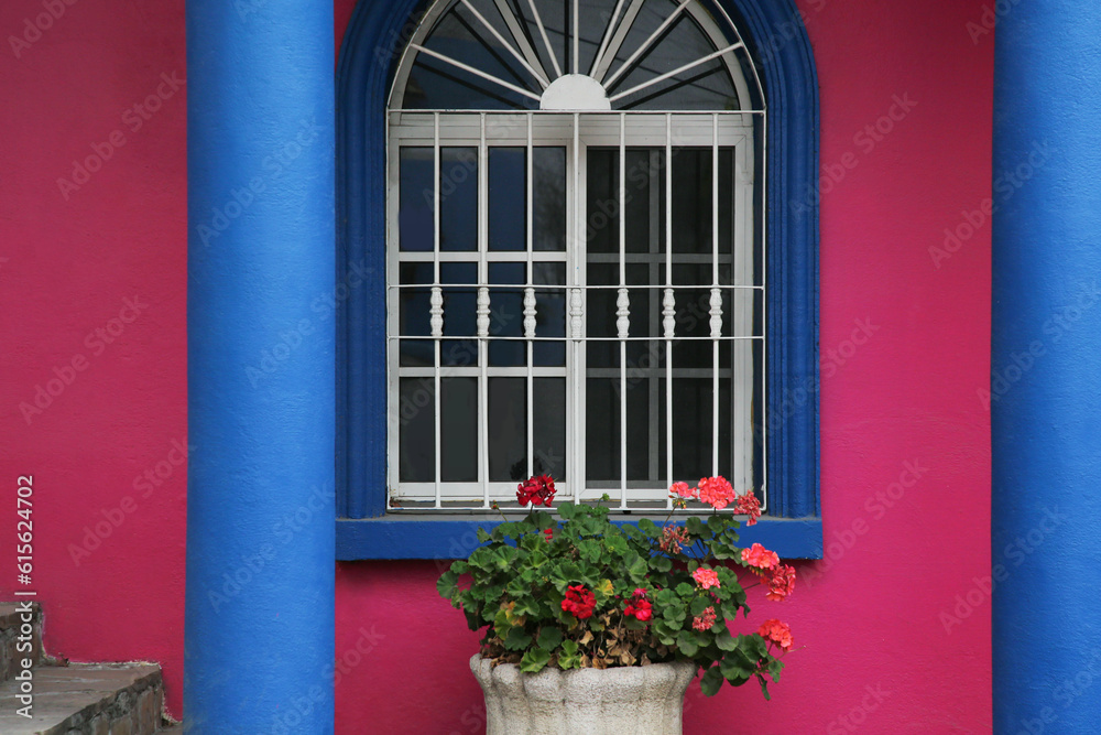 Colorful building with beautiful window and steel grilles outdoors