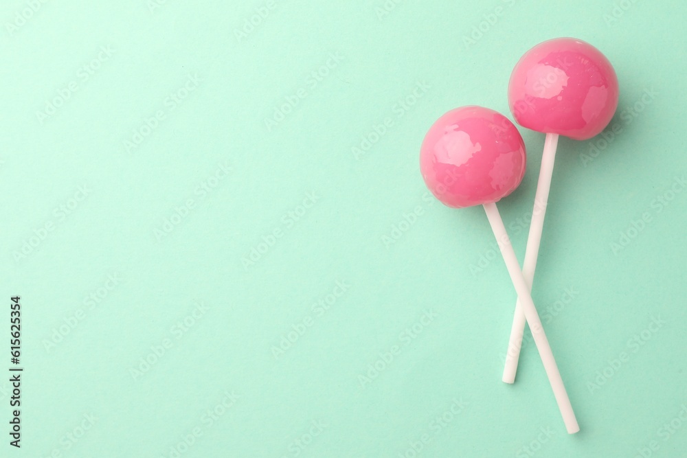Tasty lollipops on turquoise background, flat lay. Space for text Tasty lollipops on turquoise background, flat lay. Space for text