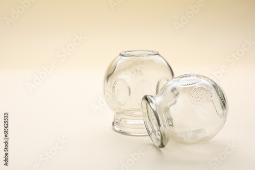 Glass cups on beige background, space for text. Cupping therapy