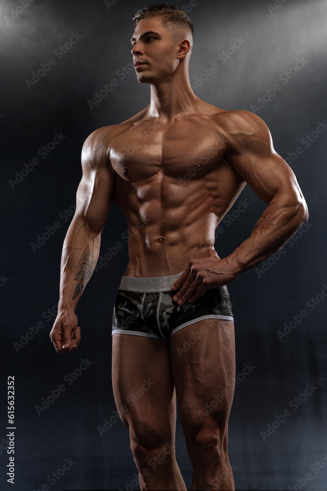 Bodybuilder showing off his perfect low fat body without clothes in studio Bodybuilder showing off his perfect low fat body without clothes in studio