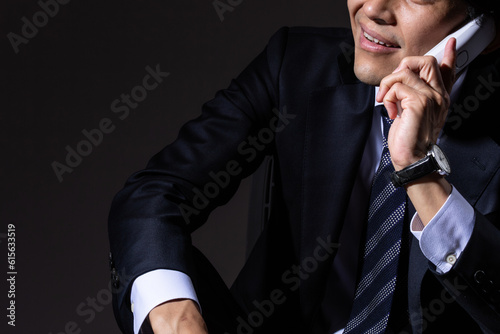 Photo 黒背景で詐欺電話をかける男性ビジネスマン