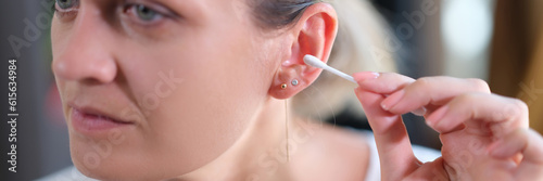 Woman cleans ears with cotton swabs closeup