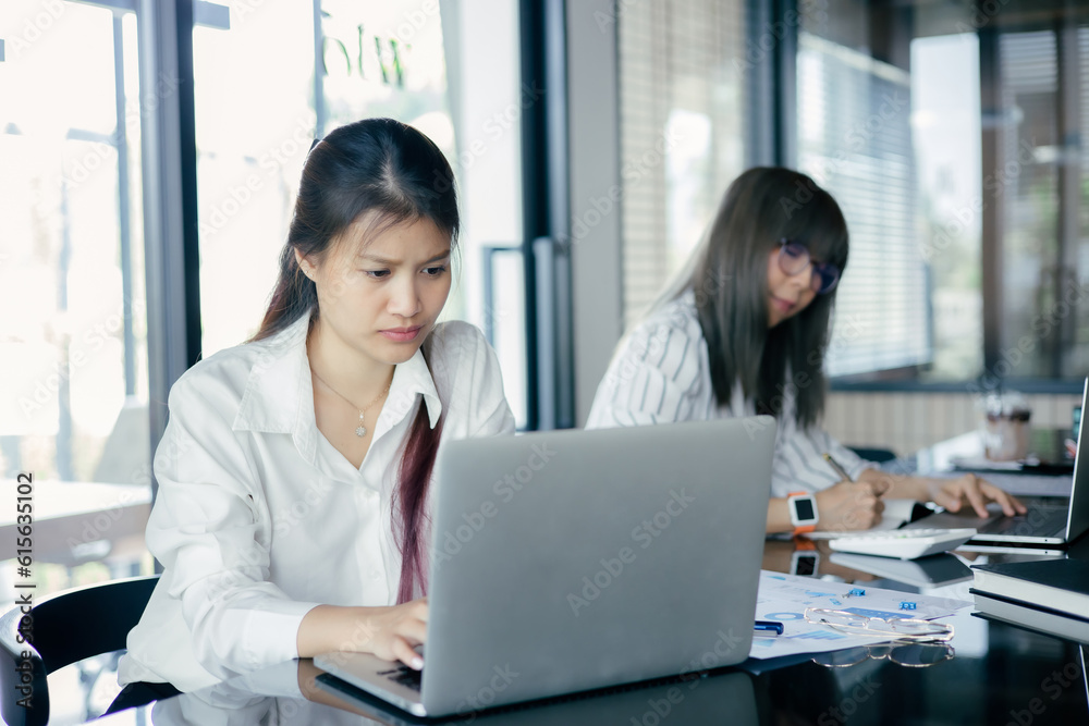 Asian Business woman use laptop to analysis data at office Asian Business woman use laptop to analysis data at office
