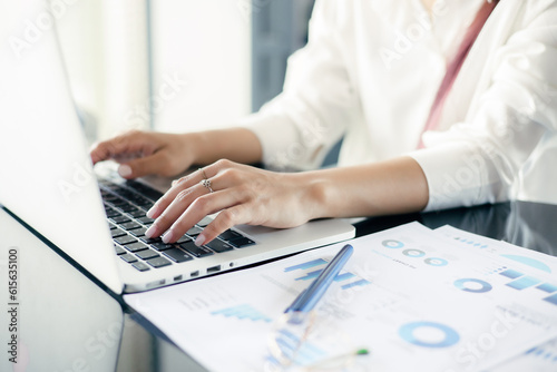 Asian Business woman use laptop to analysis data at office