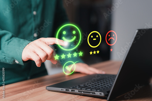 Shopper hand touching the virtual screen on the happy smile face icon for assessment feedback review satisfaction opinion and testimonial. Customer service experience and business satisfaction survey.