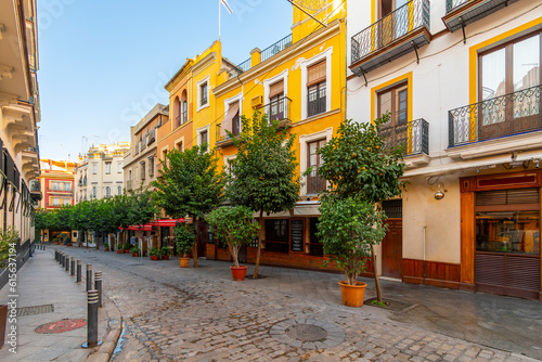 Morning view before tourists and customers of a row of restaurants and cafes in the historic Barrio Santa Cruz region of Seville  Spain  in the Andalusian region.