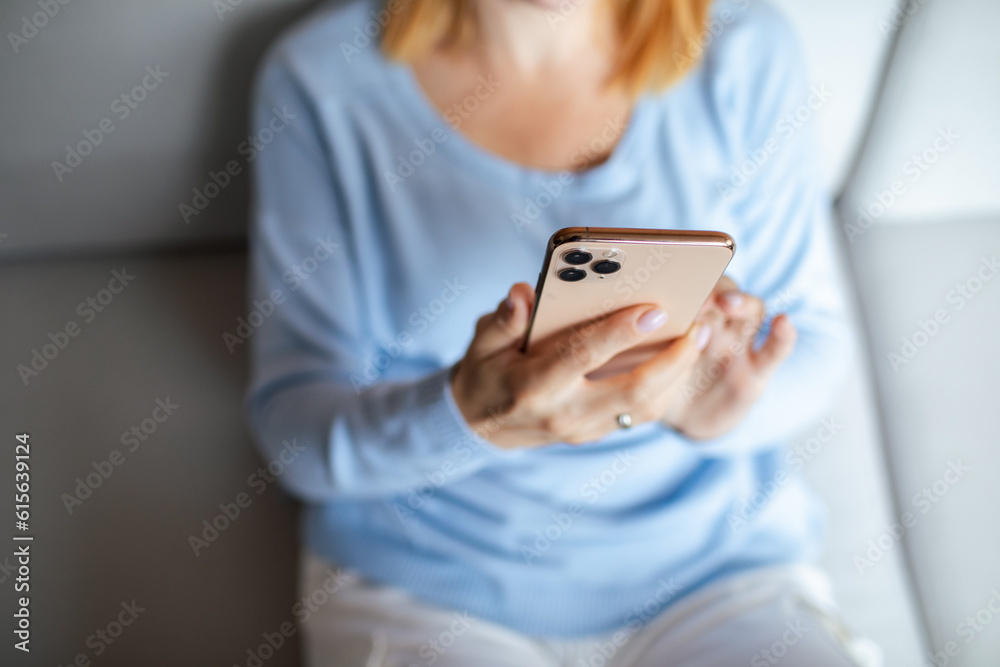 Mid adult woman using a smart phone at home Mid adult woman using a smart phone at home