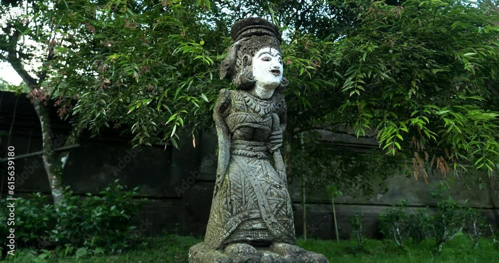 Parallax shot of a religious statue in pura tirta empul temple on bali in indonesia in ubud in beautiful garden with view of trees and leaves in slow motion Parallax shot of a religious statue in pura tirta empul temple on bali in indonesia in ubud in beautiful garden with view of trees and leaves in slow motion