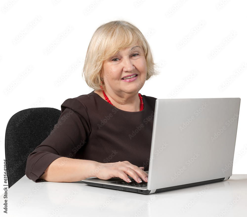 Old Woman Sitting behind Table and Typing on a Laptop - Isolated Old Woman Sitting behind Table and Typing on a Laptop - Isolated