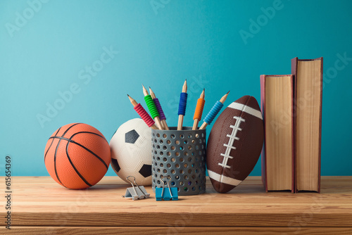 Fototapeta Naklejka Na Ścianę i Meble -  Back to school concept with pencils, basketball ball, football ball and books on wooden table over blue background