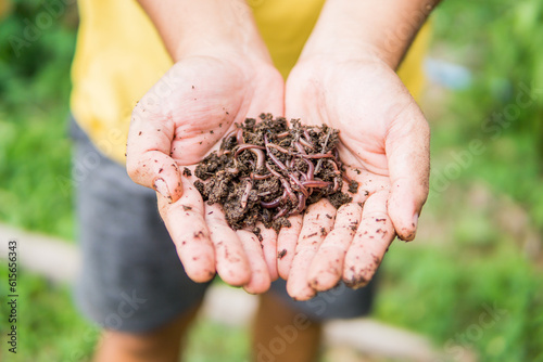 man holding worm with soil close up