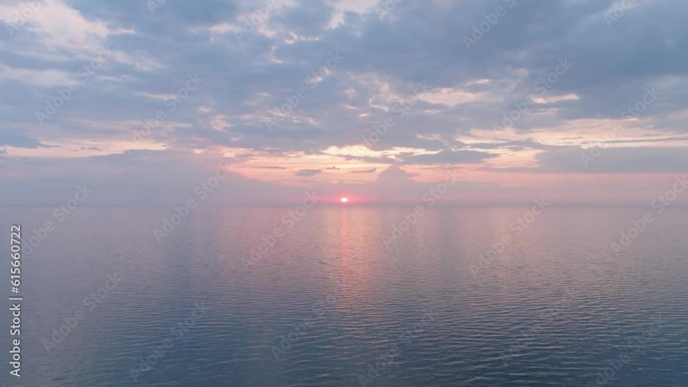 Beautiful aerial view of vibrant high contrast sunset over calm Baltic sea, clouds at the horizon, Karosta war port concrete coast fortification ruins at Liepaja, wide drone shot moving backward Beautiful aerial view of vibrant high contrast sunset over calm Baltic sea, clouds at the horizon, Karosta war port concrete coast fortification ruins at Liepaja, wide drone shot moving backward