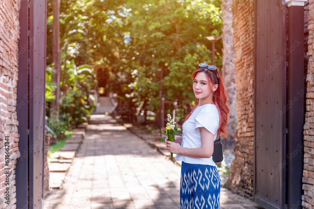 Young Asian women dressed in traditional costumes visit an old temple in Thailand. Young Asian women dressed in traditional costumes visit an old temple in Thailand.