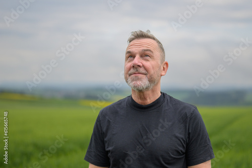 Middle aged man standing in front of a field