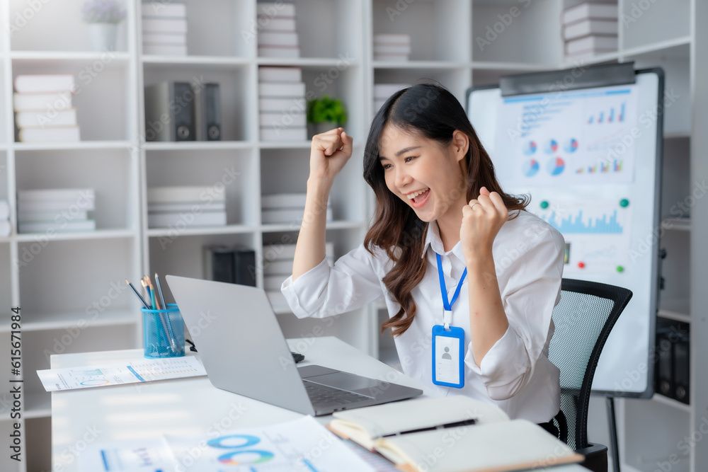 Happy asian businesswoman raising hands with victory smiling happily with laptop computer. The concept of success at work. Happy asian businesswoman raising hands with victory smiling happily with laptop computer. The concept of success at work.