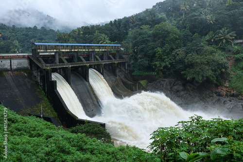 Hydroelectric dam on the river with water overflowing the dam after heavy rain in Munnar Idukki Kerala India. Indian renewable energy eco friendly electric project	