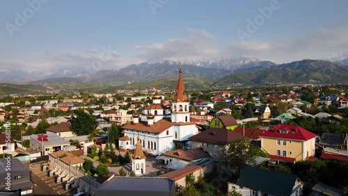 Orthodox church at sunrise agains the mountains in Almaty photo