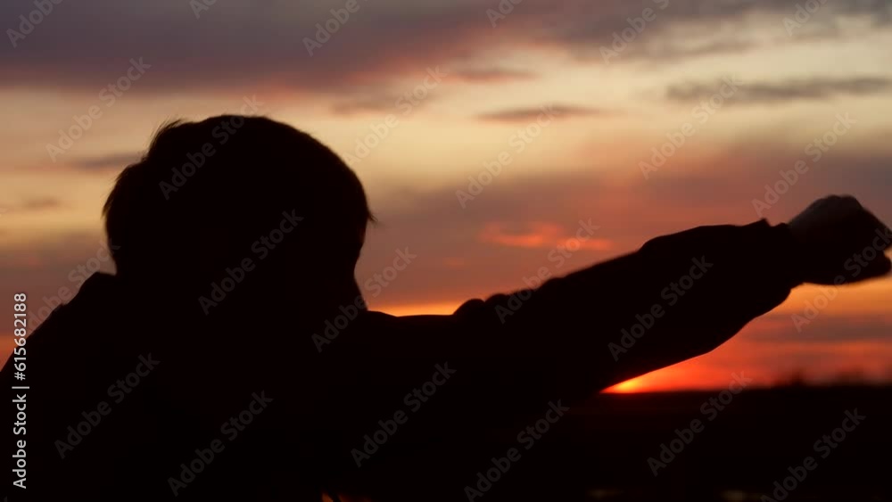 Silhouette of man in park. athlete is engaged in boxing with shadow in nature. Silhouette of guy at sunset in park. Outdoor sports training. Silhouette of sportsman fighting with a shadow in the Silhouette of man in park. athlete is engaged in boxing with shadow in nature. Silhouette of guy at sunset in park. Outdoor sports training. Silhouette of sportsman fighting with a shadow in the