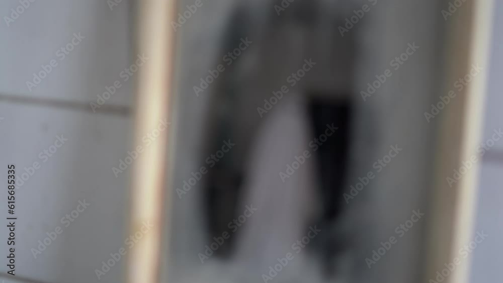 Ghost looks in the mirror on his reflection, a scary scene in an abandoned house. Halloween concept