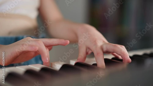 Girl with spinal cord injury plays piano standing in room at home. Talented child practices music during rehabilitation closeup on blurred background