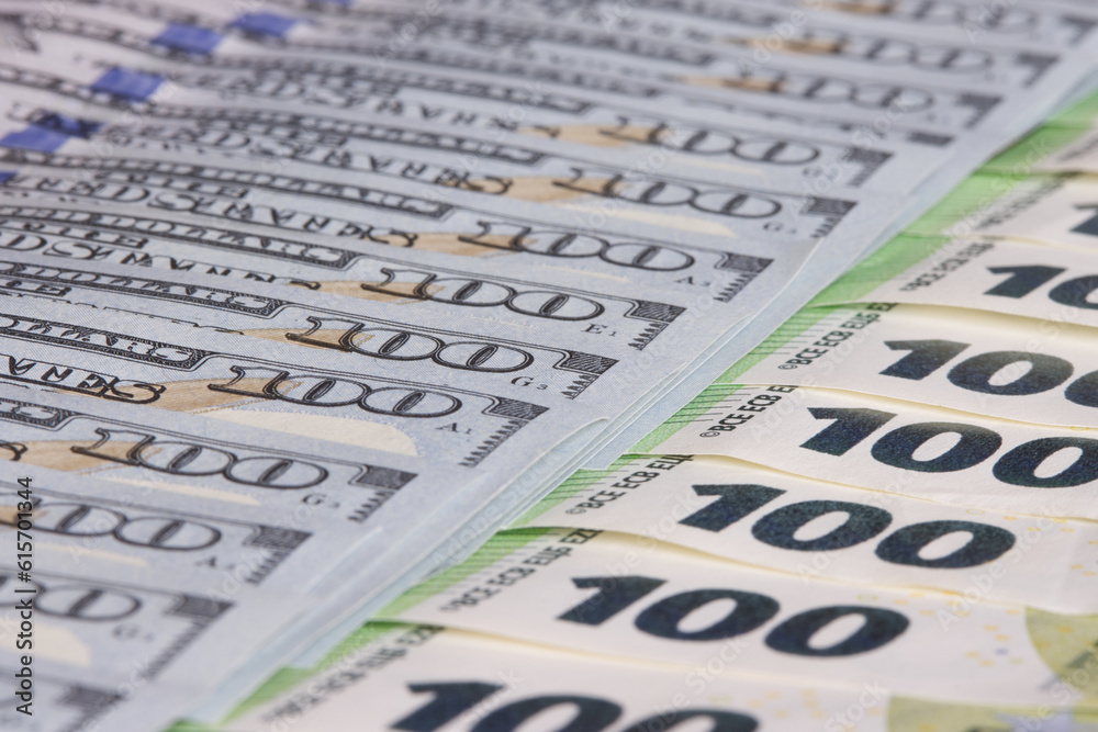 One hundred dollar bills next to one hundred euro bills., Currency exchange rate concept, selective focus. One hundred dollar bills next to one hundred euro bills., Currency exchange rate concept, selective focus.