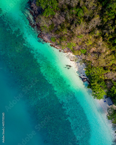 Aerial view, top view, amazing nature background. The water colors are beautiful and bright. Azure beach with rocky mountains and clear ocean water of Thailand on a sunny day. Landscape background