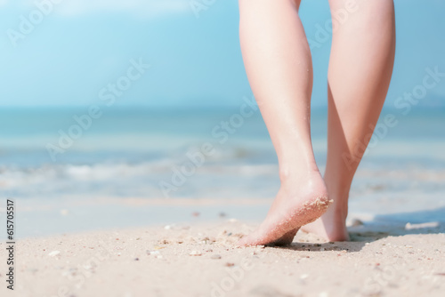 Close up woman legs walking on tropical beach with smooth wave abstract background. Travel vacation and freedom feel good concept. Vintage tone color style.