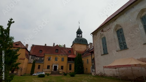 Lielstraupe Medieval Castle in the Village of Straupe in Vidzeme, in Northern Latvia. 4K Shot Lielstraupe Castle United in One Corps With the Church Surrounded by a Park With Pond. Rainy Day photo