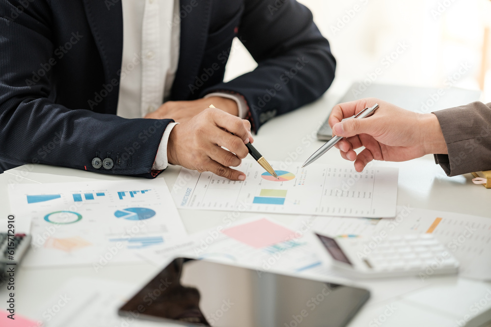 Team of two asian male business people working together discussing new financial graph data on office table with laptop and digital tablet. Team of two asian male business people working together discussing new financial graph data on office table with laptop and digital tablet.