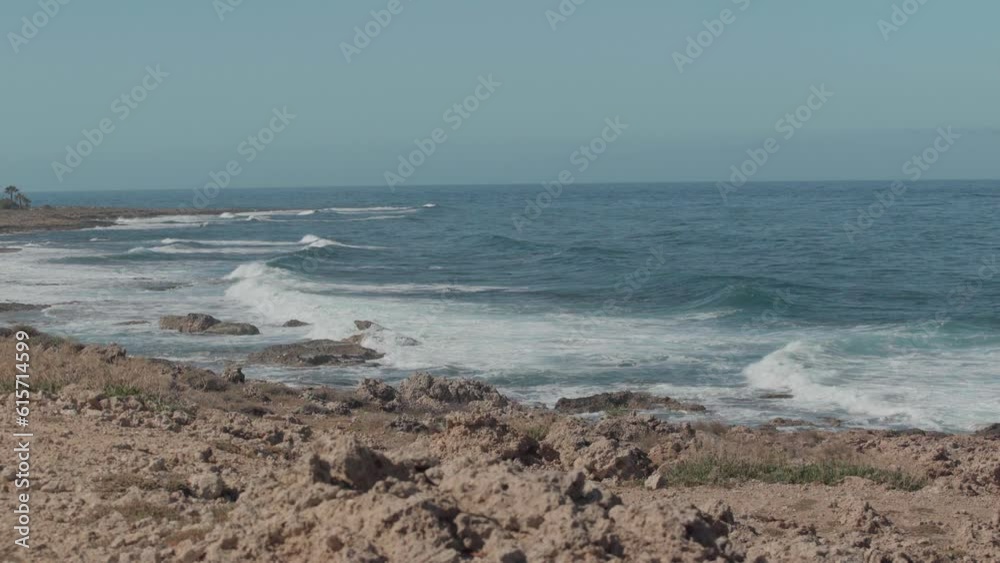 Endless ocean on sunny summer day outdoors with azure blue waves rolling on rocky coast. Wide shot Mediterranean sea in sunshine on Cyprus with no people Endless ocean on sunny summer day outdoors with azure blue waves rolling on rocky coast. Wide shot Mediterranean sea in sunshine on Cyprus with no people