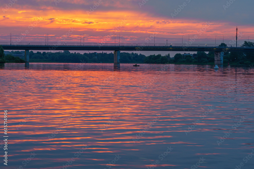 Obraz premium Beautiful summer sunrise over the river. The bridge against the background of the sunrise on a summer morning.