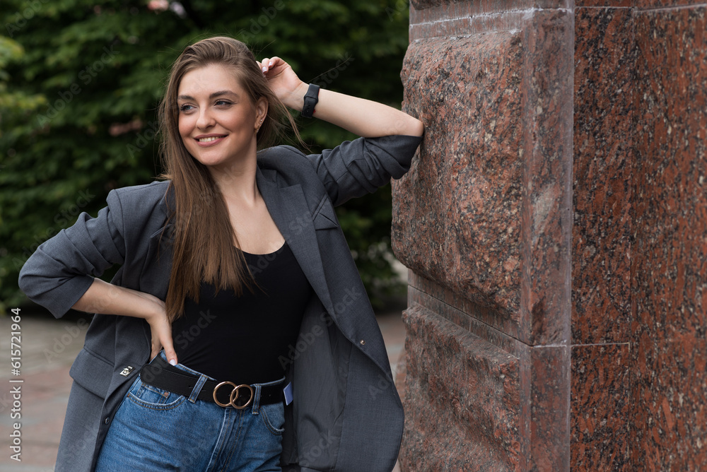 Portrait of a happy smiling woman in casual clothes while walking around the city.