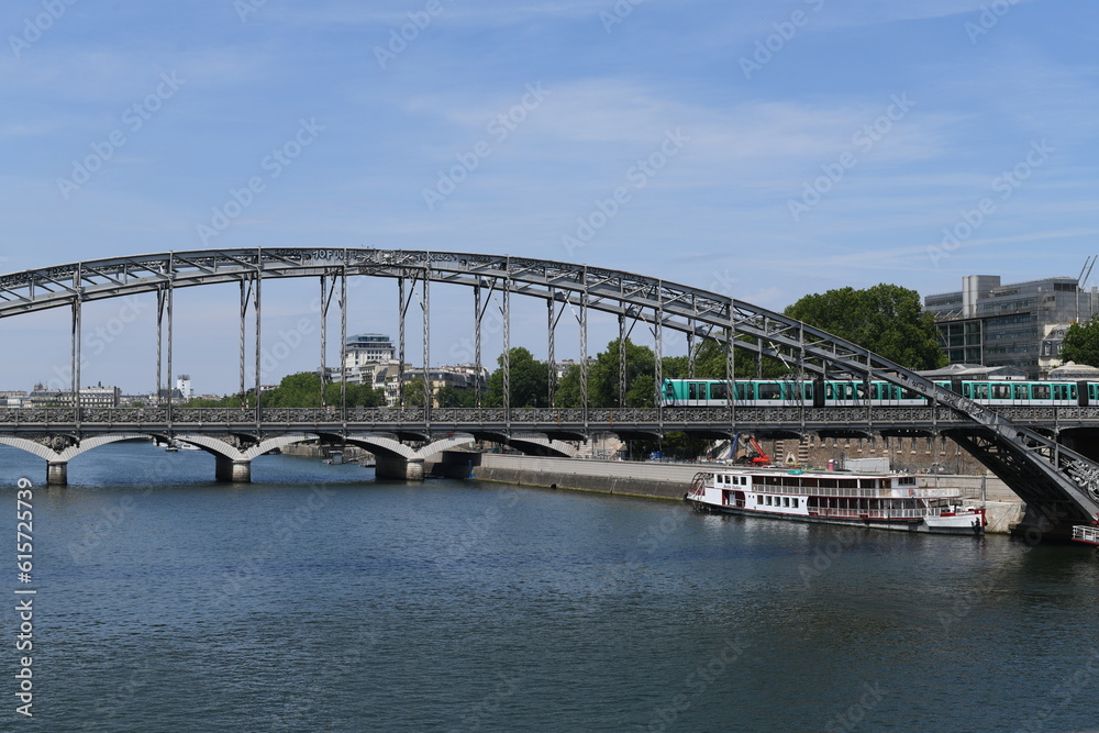 Parisian subway passing on an iron bridge overlooking the seine. 