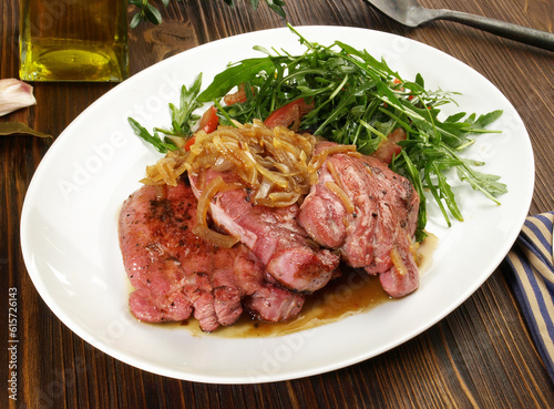 Fine Meat - Boiled Cured Veal Tongue Meat Slices with roasted Onions and Salad on wooden Background