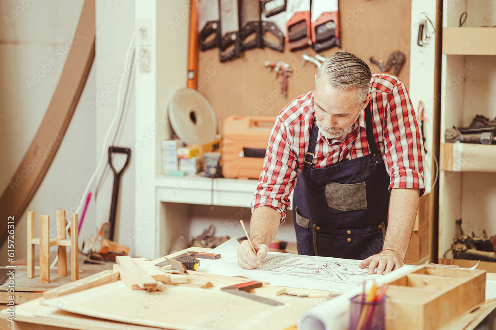 Senior professional engineer architect male working design drawing floor plan home furniture and renovate in workshop. Senior professional engineer architect male working design drawing floor plan home furniture and renovate in workshop.