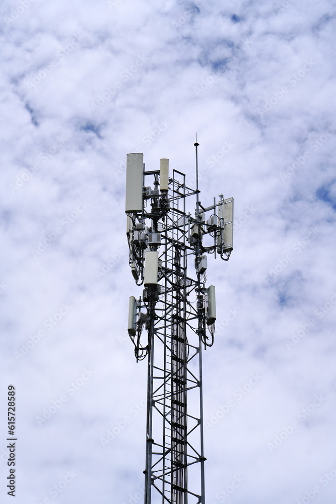 Telecommunication tower of 4G and 5G cellular. Macro Base Station. 5G radio network telecommunication equipment with radio modules and smart antennas mounted on a metal against cloulds sky background. Telecommunication tower of 4G and 5G cellular. Macro Base Station. 5G radio network telecommunication equipment with radio modules and smart antennas mounted on a metal against cloulds sky background.