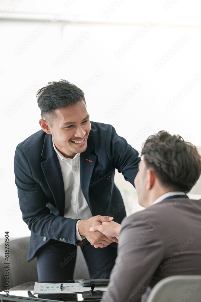 Smiling asian businessman shaking client hand, closing successful deal, satisfied hr manager hiring new employee, business partners handshaking at meeting. Smiling asian businessman shaking client hand, closing successful deal, satisfied hr manager hiring new employee, business partners handshaking at meeting.