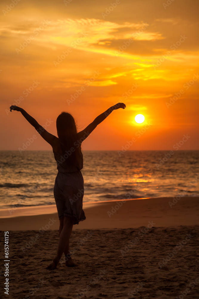 Silhouette full length of young woman posing arms raised on tropical sea sunset, rear view. Slim lady in beachwear relaxing enjoying on tropic side. Travel vacation holiday concept. Copy ad text space